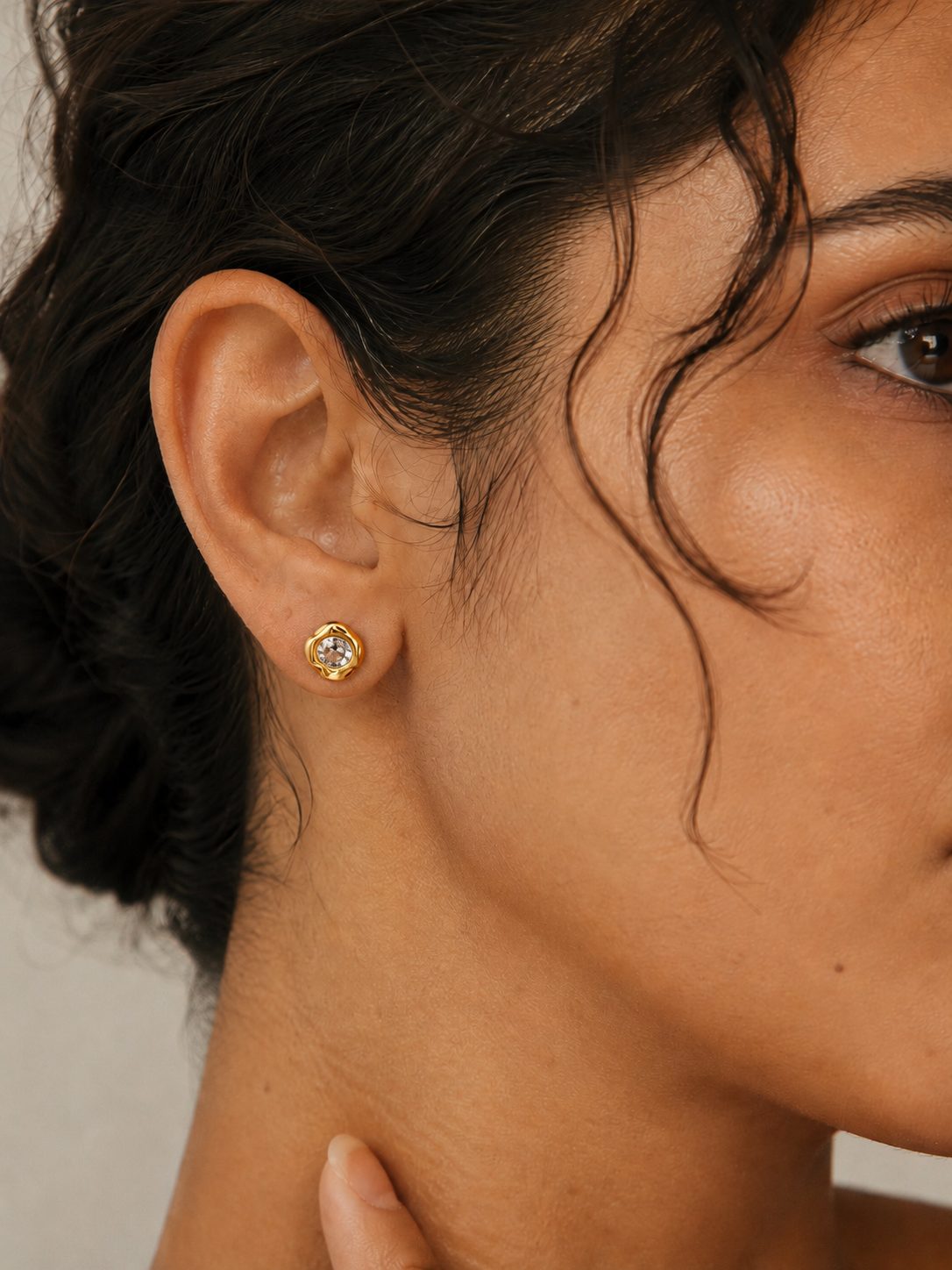 Model wearing the Halo Stud — a round cubic zirconia set in an organic molten-edge 18K gold bezel — Zoé Jewelry.