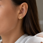 Model wearing the Carré Studs — textured square gold studs with a molten finish — Zoé Jewelry.