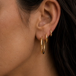Model wearing Classic Hoops in small, medium, and large stacked up the ear — slim 18K gold hoops that step up in size — Zoé Jewelry