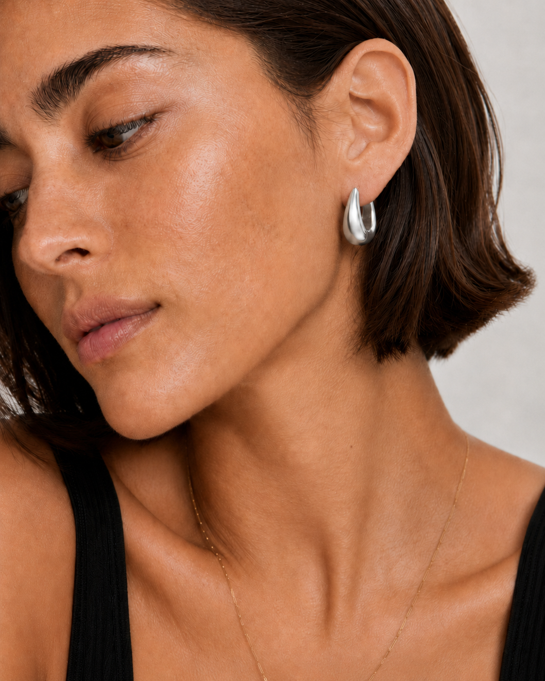 Model wearing the Eden Silver Hoops — chunky rhodium-plated silver teardrop dome hoops — Zoé Jewelry.