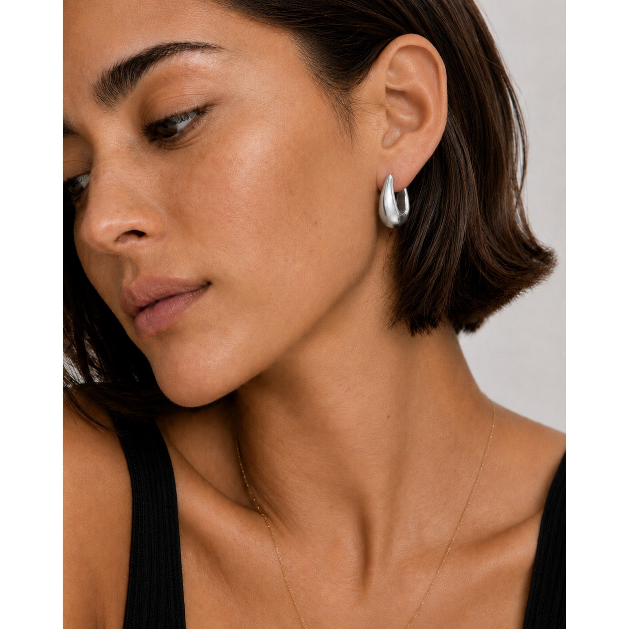 Model wearing the Eden Silver Hoops — chunky rhodium-plated silver teardrop dome hoops — Zoé Jewelry.