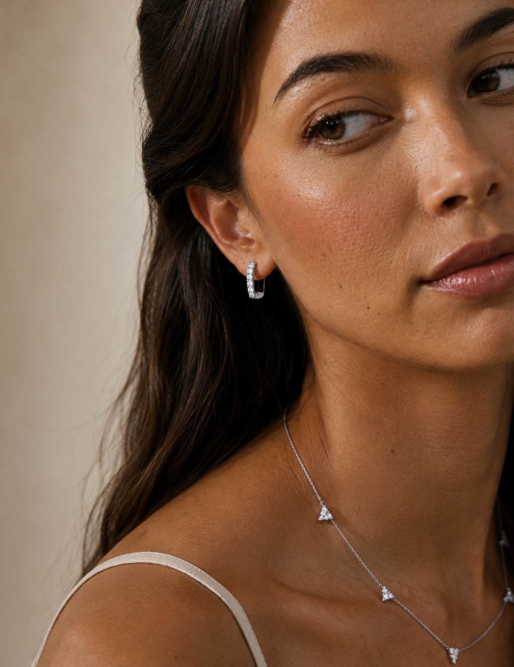Model wearing the Elise Pavé Huggies — elongated silver-tone huggie hoops set with cubic zirconia — Zoé Jewelry.