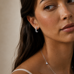 Model wearing the Elise Pavé Huggies — elongated silver-tone huggie hoops set with cubic zirconia — Zoé Jewelry.