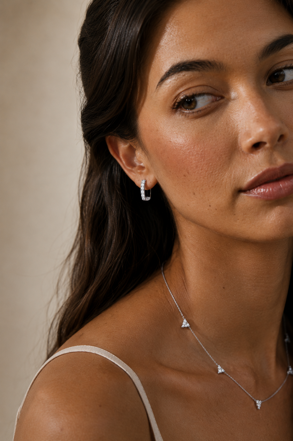 Model wearing the Elise Pavé Huggies — elongated silver-tone huggie hoops set with cubic zirconia — Zoé Jewelry.