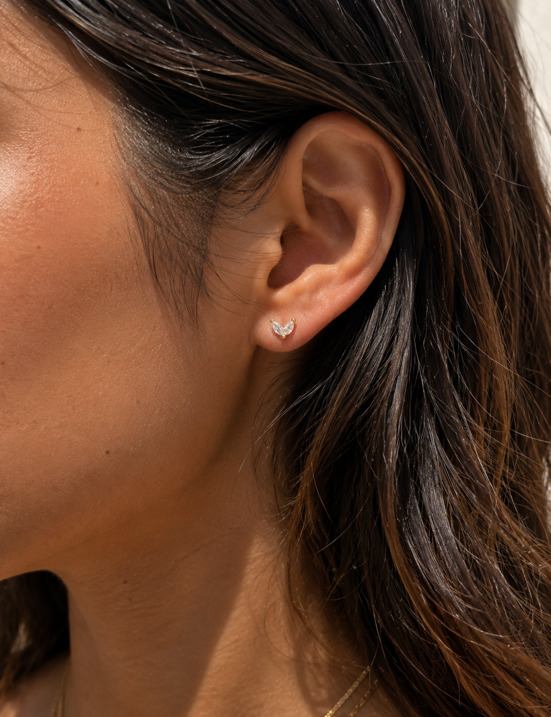 Model wearing the Ember Studs — dainty gold petal studs with two marquise-cut cubic zirconia — Zoé Jewelry.