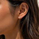Model wearing the Ember Studs — dainty gold petal studs with two marquise-cut cubic zirconia — Zoé Jewelry.