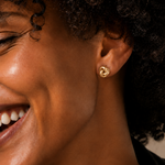Model wearing the Eternal Knot Studs — dainty gold love-knot stud earrings — Zoé Jewelry.