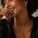 Model wearing the Eternity Huggie — bezel-set CZ 18K gold huggie hoops styled with a gold stud — Zoé Jewelry.