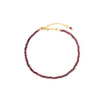 Garnet Bracelet, faceted deep-red garnet gemstone beads on an 18K gold-plated chain with a Zoé bar tag.