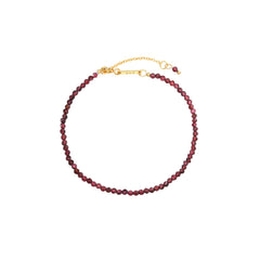Garnet Bracelet, faceted deep-red garnet gemstone beads on an 18K gold-plated chain with a Zoé bar tag.