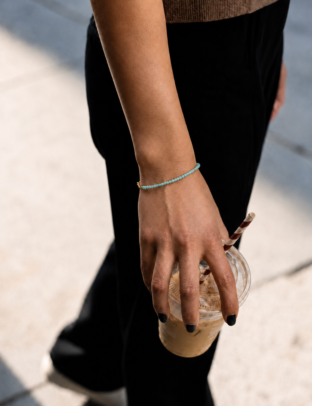 Model wearing the Marisol Bracelet — dainty natural green gemstone beads on an 18K gold-plated chain — Zoé Jewelry.
