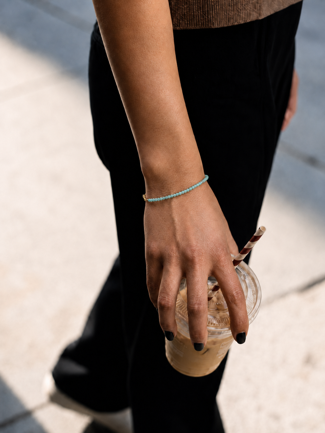 Model wearing the Marisol Bracelet — dainty natural green gemstone beads on an 18K gold-plated chain — Zoé Jewelry.

