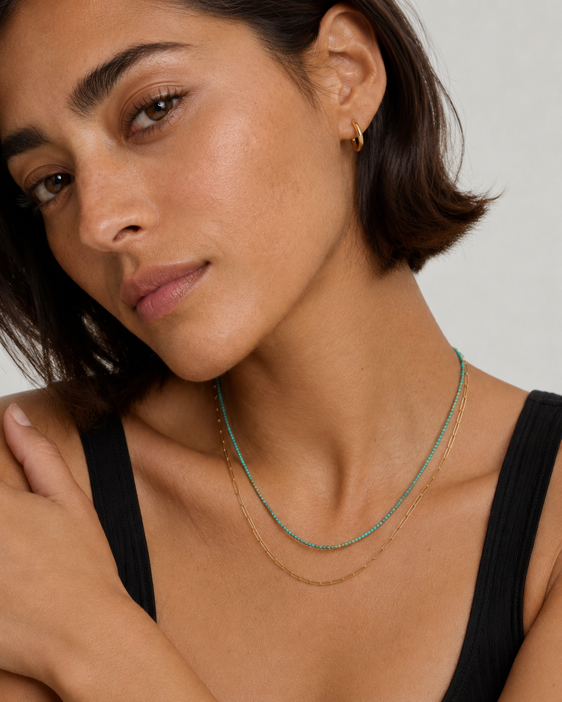 Model wearing the Marisol natural green gemstone necklace layered with a gold paperclip chain — Zoé Jewelry.