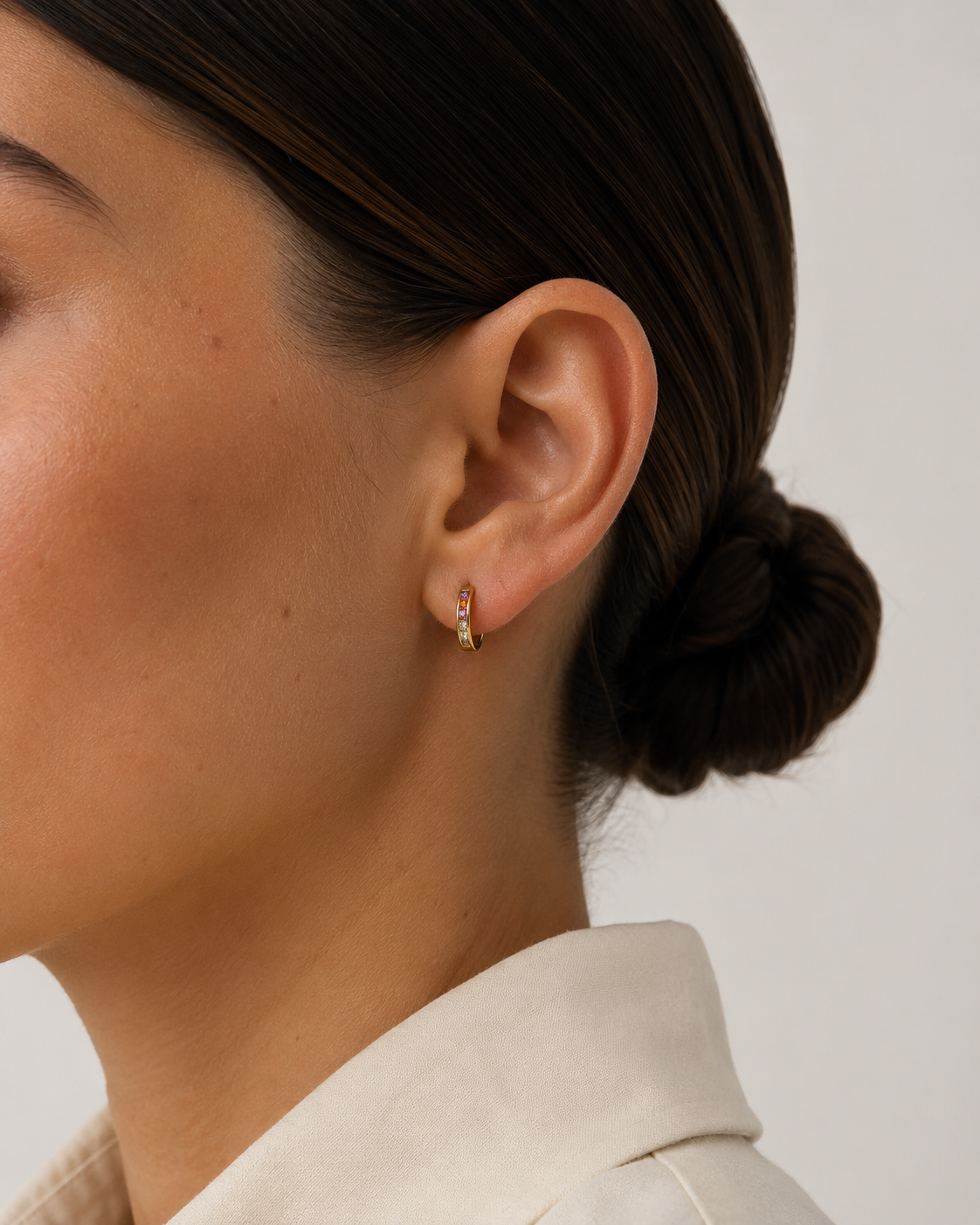 Model wearing the Noelle Hoops — small gold huggie hoops with multicoloured CZ stones — Zoé Jewelry.