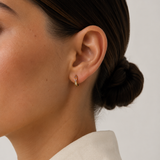 Model wearing the Noelle Hoops — small gold huggie hoops with multicoloured CZ stones — Zoé Jewelry.