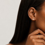 Model wearing the Odette Stud — a gold stud pairing a button pearl with a baguette-cut cubic zirconia — Zoé Jewelry.