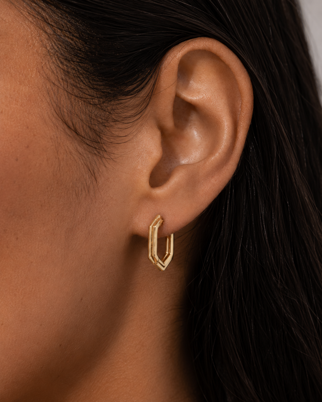 Model wearing the Rivé Hoops — angular hexagon gold hoop earrings — Zoé Jewelry.