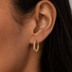 Model wearing the Rivé Hoops — angular hexagon gold hoop earrings — Zoé Jewelry.
