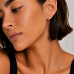 Model wearing the Saddle Up Studs — a tiny 18K gold horseshoe stud with pavé CZ — Zoé Jewelry.