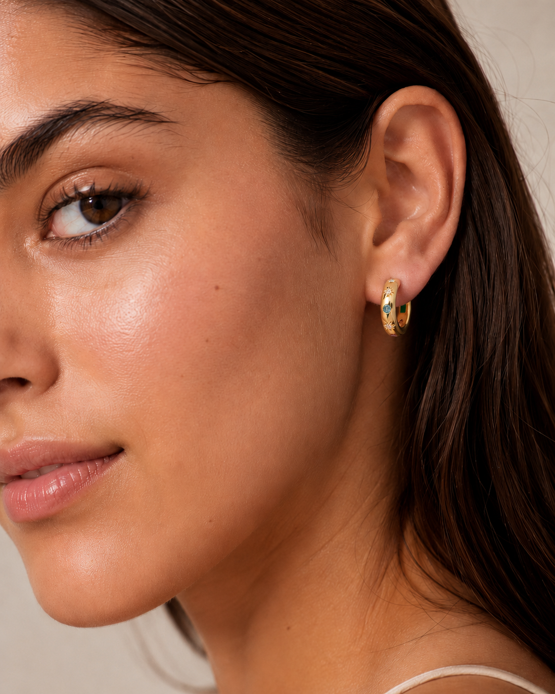 Model wearing the Stardust Hoops with the engraved star side facing out — reversible 18K gold hoops from Zoé Jewelry.