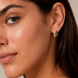 Model wearing the Stardust Hoops with the engraved star side facing out — reversible 18K gold hoops from Zoé Jewelry.