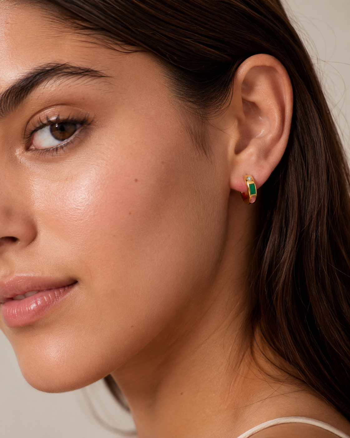 Model wearing the Stardust Hoops with the jewel-toned stone side facing out — reversible 18K gold hoops from Zoé Jewelry.
