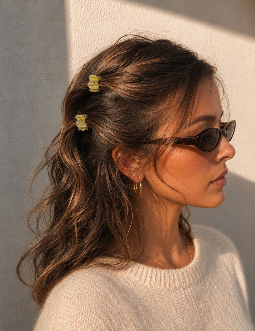 Model wearing two Thea Mini Clips in Citrus in half-up waves — bright yellow marbled acetate claw clips from Zoé Jewelry.