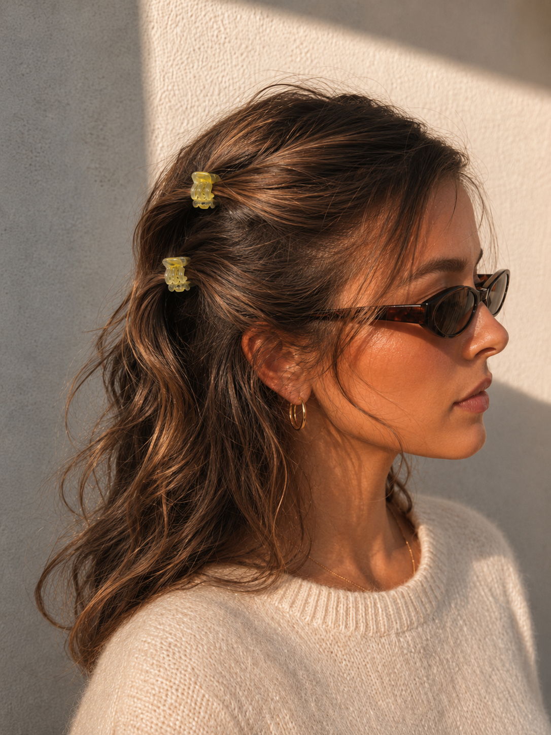 Model wearing two Thea Mini Clips in Citrus in half-up waves — bright yellow marbled acetate claw clips from Zoé Jewelry.