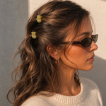 Model wearing two Thea Mini Clips in Citrus in half-up waves — bright yellow marbled acetate claw clips from Zoé Jewelry.
