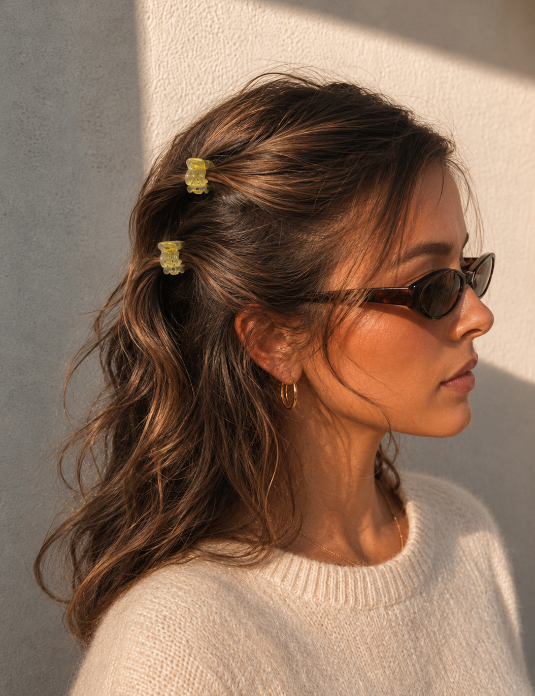 Model wearing two Thea Mini Clips in Citrus in half-up waves — bright yellow marbled acetate claw clips from Zoé Jewelry.