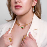 Model wearing Theo fine cable chain necklace in 18K gold-plated finish at the collarbone