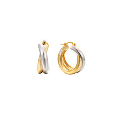 Two-tone twisted crossover hoop earrings in gold and silver, 19 mm, shown as a pair and worn by a model in a black turtleneck.
