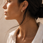 Model wearing the Vera Huggies — domed pavé CZ huggie hoops in 18K gold — Zoé Jewelry.