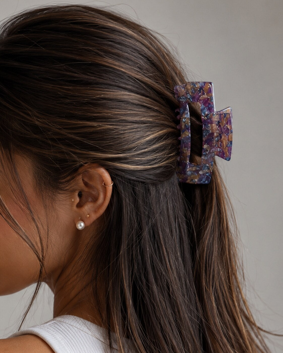 Model wearing Victoria rectangular claw clip in Lavender Latte marble cellulose acetate, close-up side view