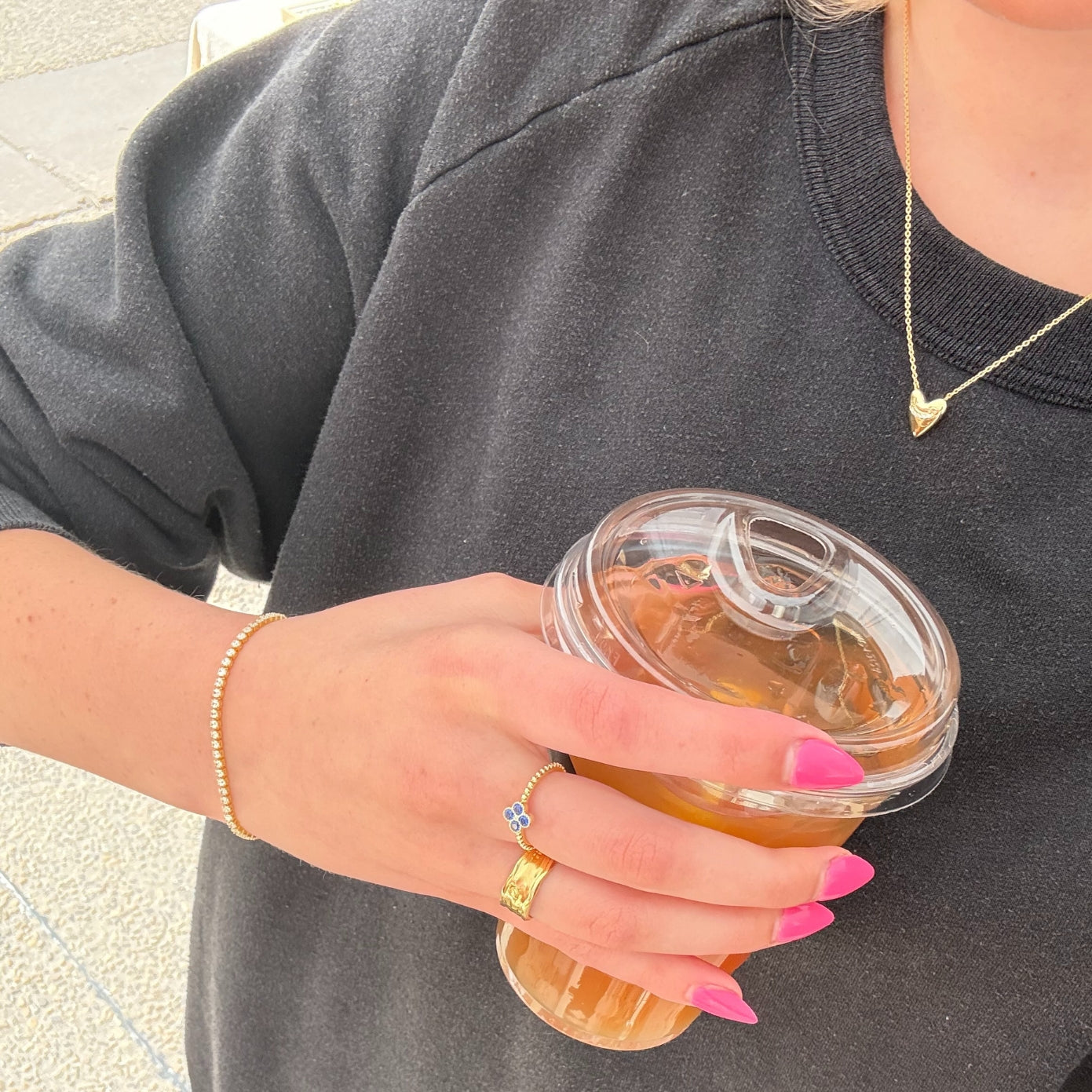 Model wearing a dainty gold puffed heart pendant necklace with a cubic zirconia accent at the neck, in 18k gold plating.