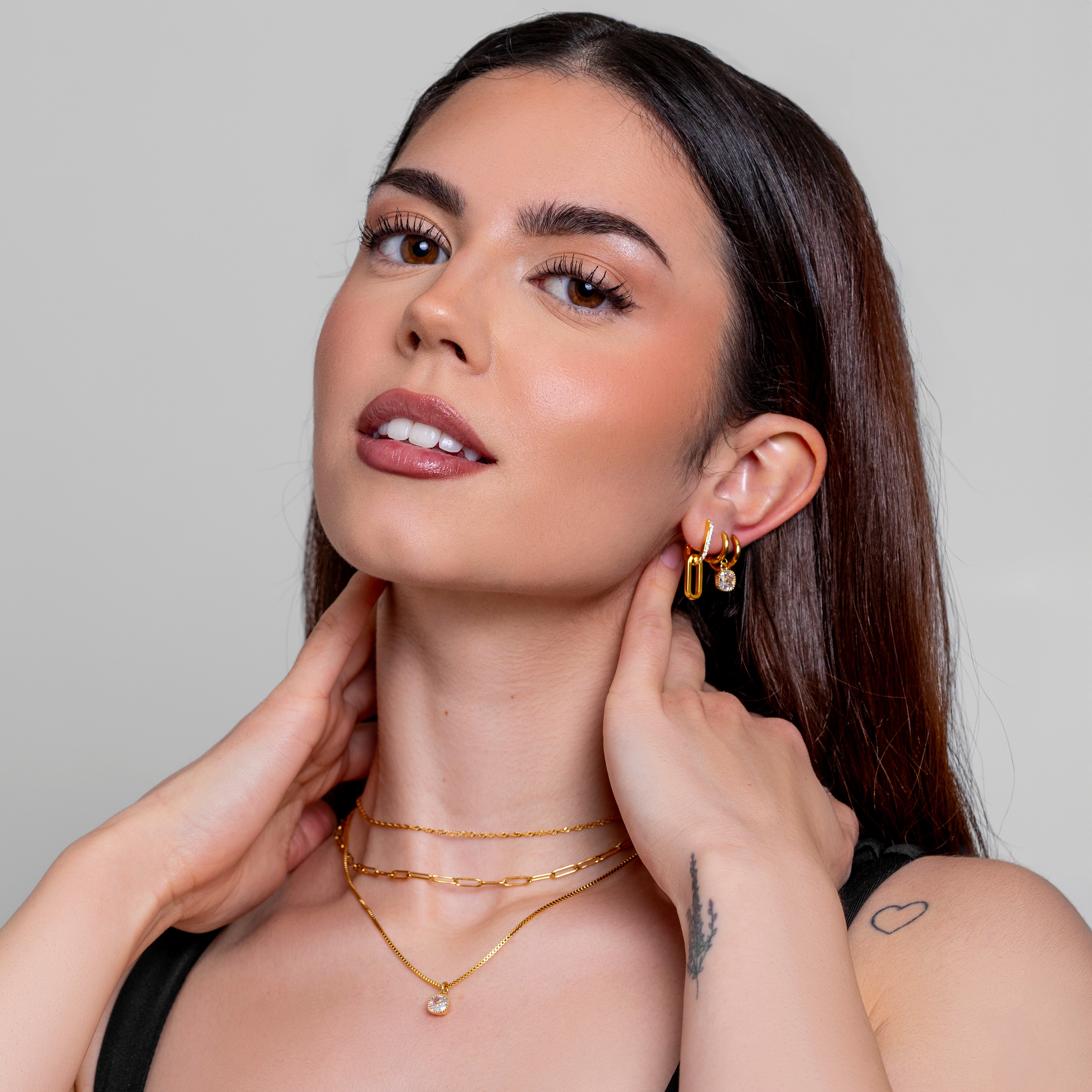 Model wearing a gold paperclip chain necklace, in 18k gold plating.