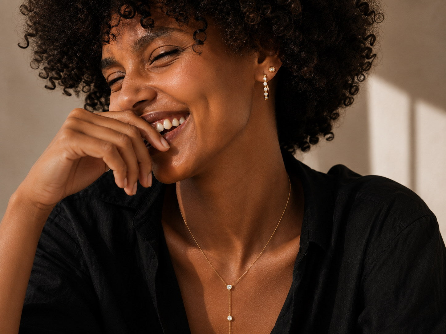 Smiling woman wearing Zoé 18K gold-plated pearl earrings and a layered lariat necklace — everyday luxury jewelry designed in Calgary.
