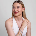 Model wearing a gold oval cable link chain bracelet on the wrist, 18k gold-plated stainless steel.