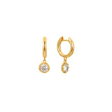 Gold huggie hoop earrings with a round clear cubic zirconia solitaire drop, in 18k gold plating.