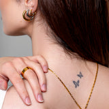 Model wearing a textured gold tile band ring on the finger, 18k gold plating.