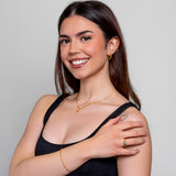 Model wearing a dainty gold oval-bead chain bracelet on the wrist, in 18k gold plating, soft natural light.