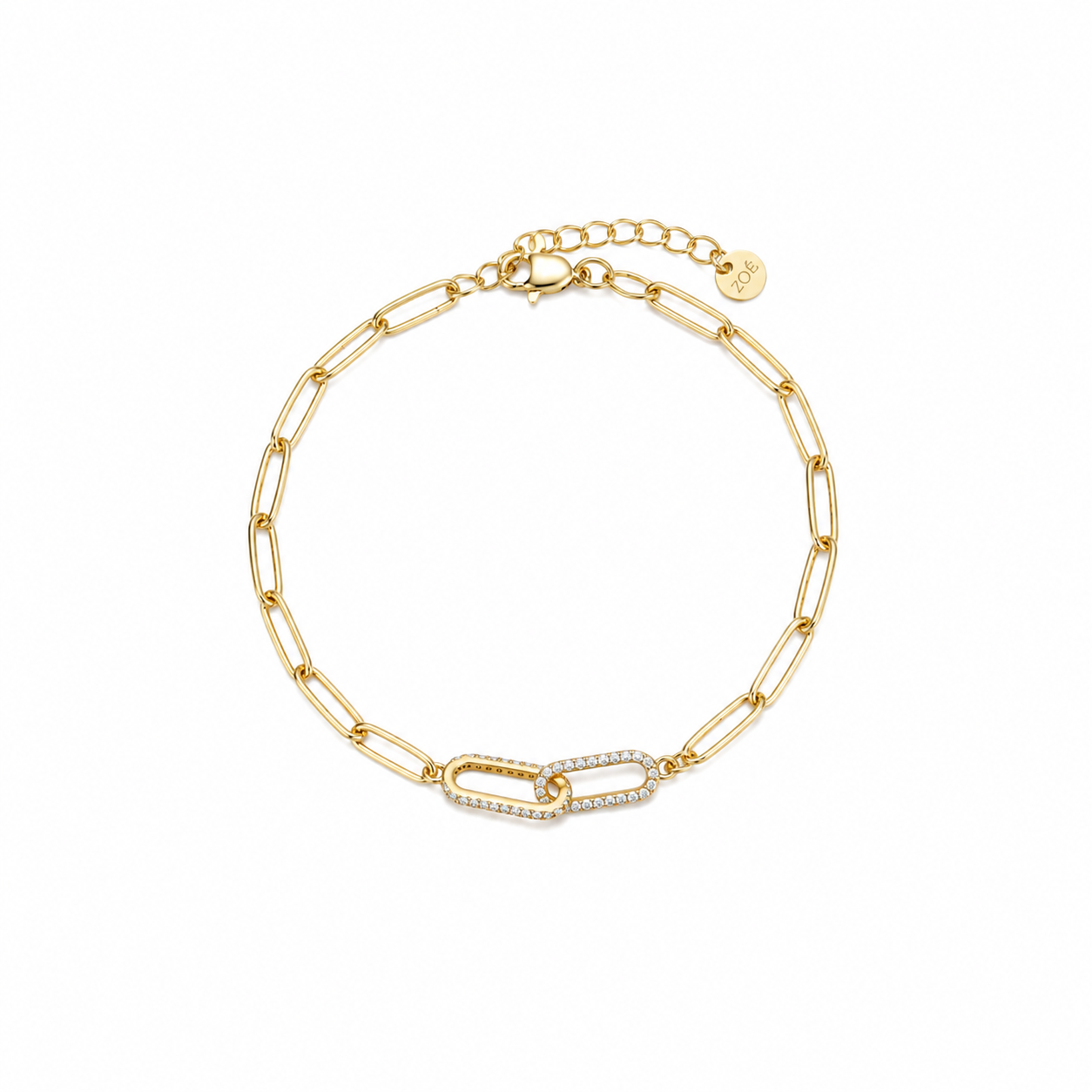 Gold paperclip chain bracelet with a cubic zirconia pavé centre link, lobster clasp, adjustable extender, and Zoé disc tag, in 18k gold plating.