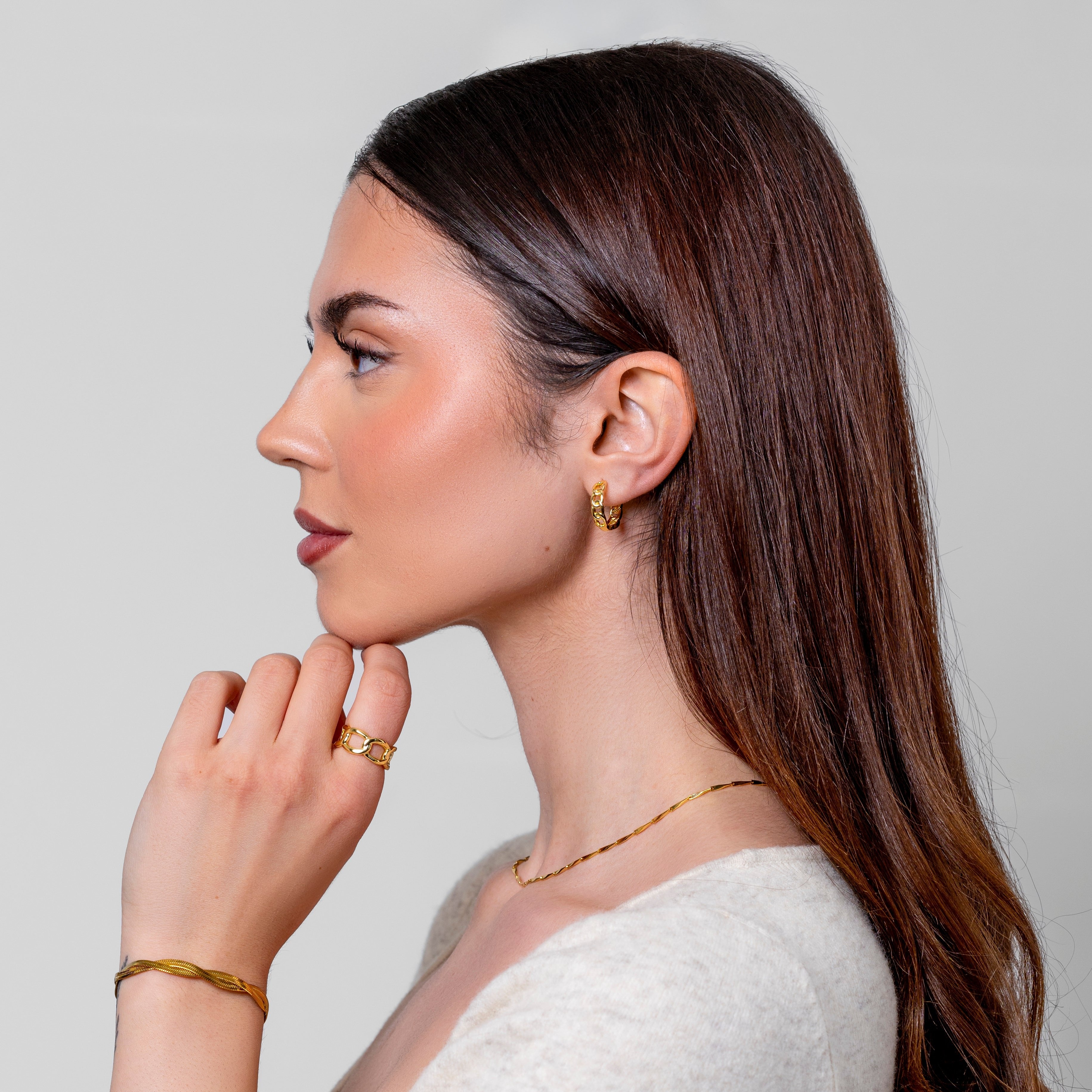 Model wearing a fine twisted gold chain necklace at the neck, in 18k gold plating.