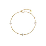 Dainty gold beaded cable chain bracelet with three cubic zirconia four-petal flower stations, lobster clasp, adjustable extender, and Zoé disc tag, in 18k gold plating.