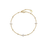 Dainty gold beaded cable chain bracelet with three cubic zirconia four-petal flower stations, lobster clasp, adjustable extender, and Zoé disc tag, in 18k gold plating.