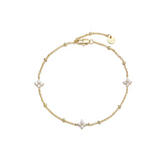 Dainty gold beaded cable chain bracelet with three cubic zirconia four-petal flower stations, lobster clasp, adjustable extender, and Zoé disc tag, in 18k gold plating.