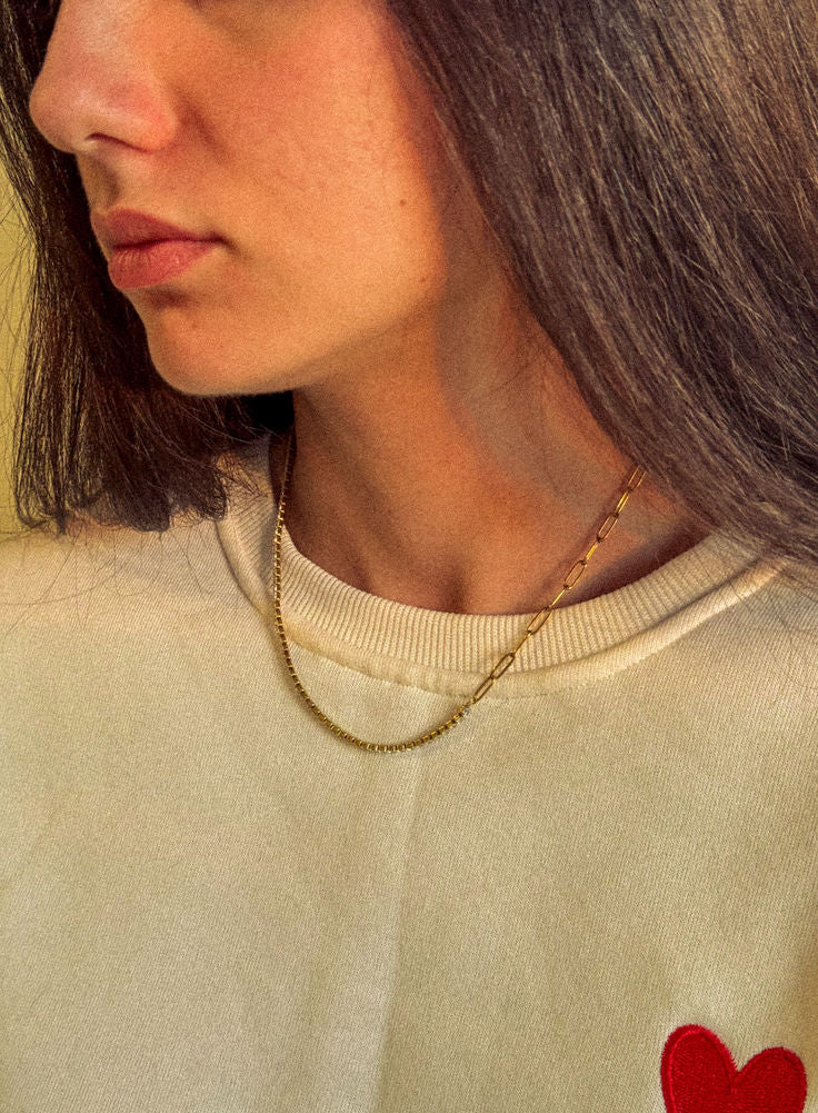  Customer wearing a dainty Zoé gold chain necklace with a beige tee in the sun — Zoé On You.