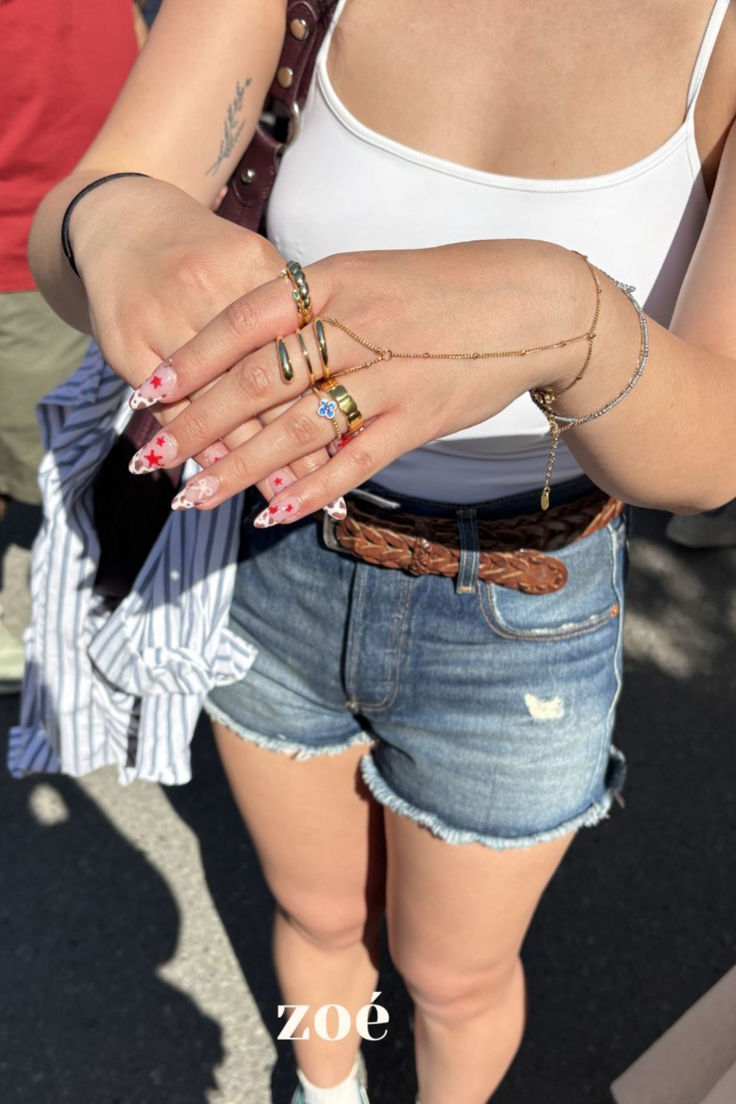 Customer wearing stacked Zoé gold rings and layered bracelets with denim shorts — Zoé On You.